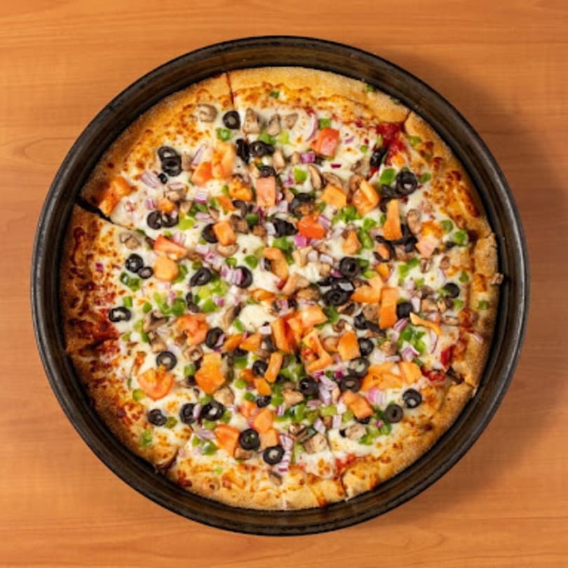 Watt A Pizza's veggie pizza, topped with olives, mushrooms, onions, green peppers, and tomatoes.